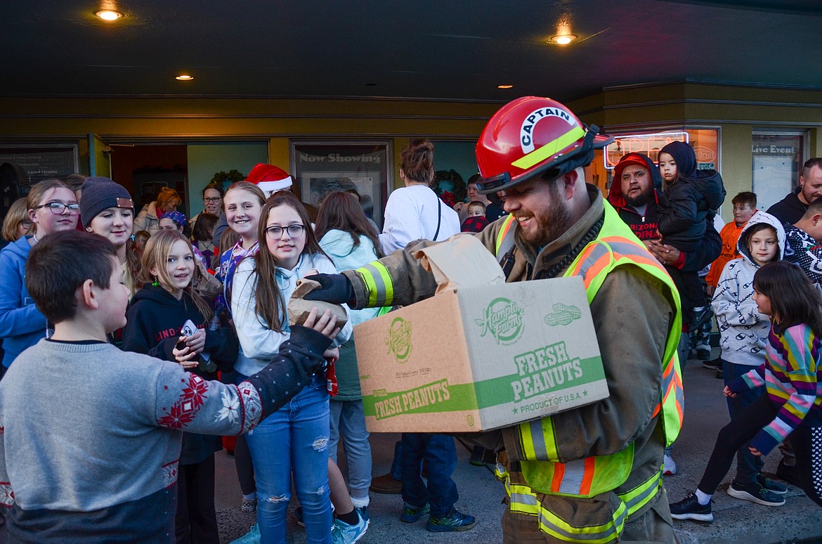 Ritzville Volunteer Firefighter Andrew Carlson hands out treat bags after the annual Children's Movie Matinee at the historic Ritz Theatre during last year’s Ritzville Winter Fest.