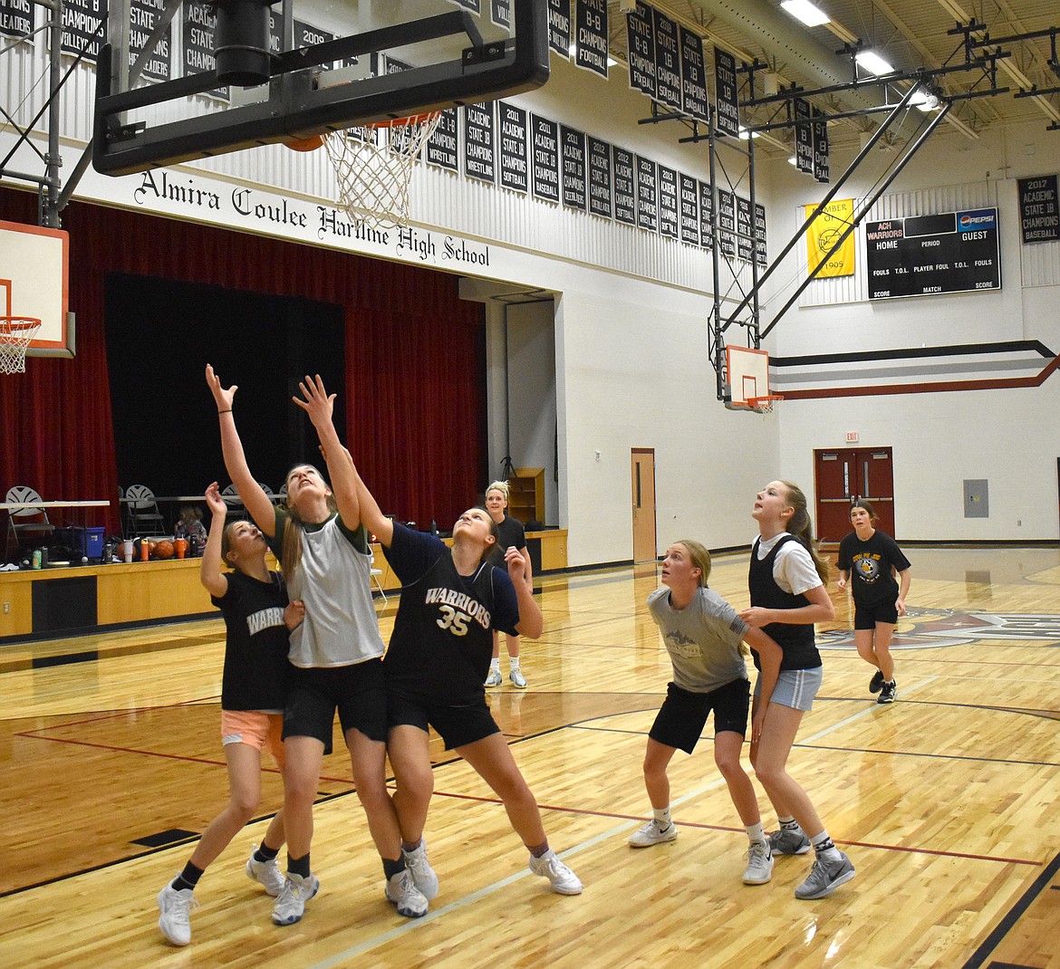 Peyton Roberts and Lainee Baergen pin Emma Brummett at the Almira/Coulee-Hartline Warriors’ practice Nov. 20.