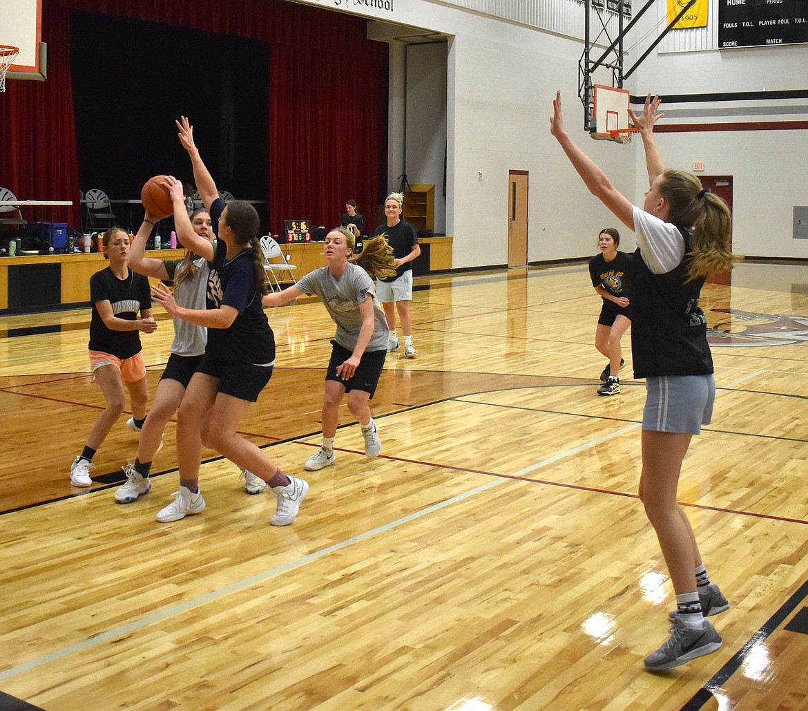 A double-teamed Emma Brummett looks to pass to Emily Evers at the Almira/Coulee-Hartline Warriors’ practice Nov. 20.