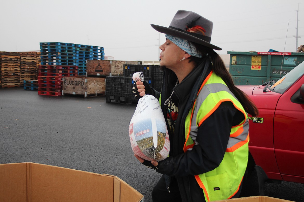 Michael Roelle picks up a turkey to load for a customer at the Moses Lake Food Bank Monday.