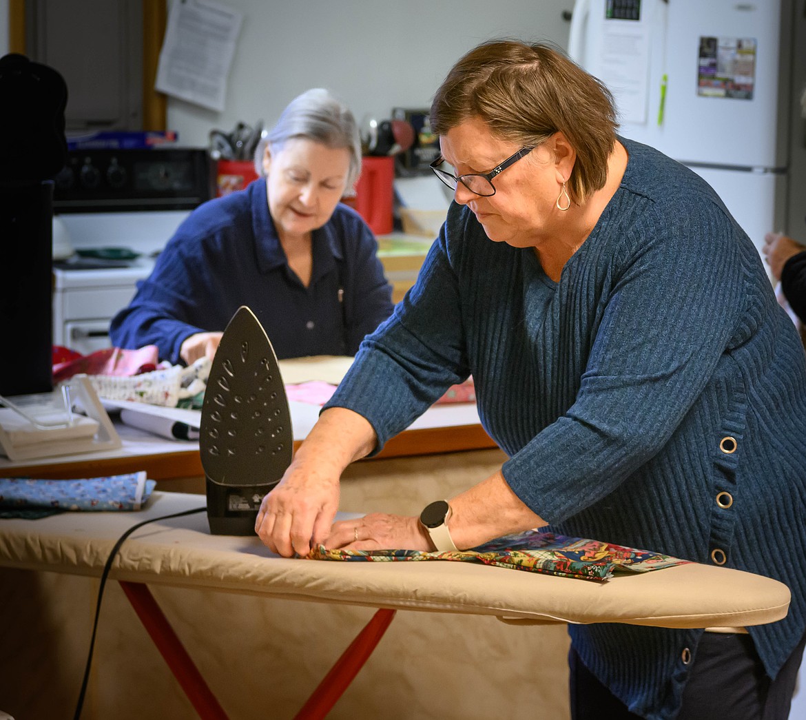 LeeAnn Hafner irons Christmas stockings. (Tracy Scott/Valley Press)