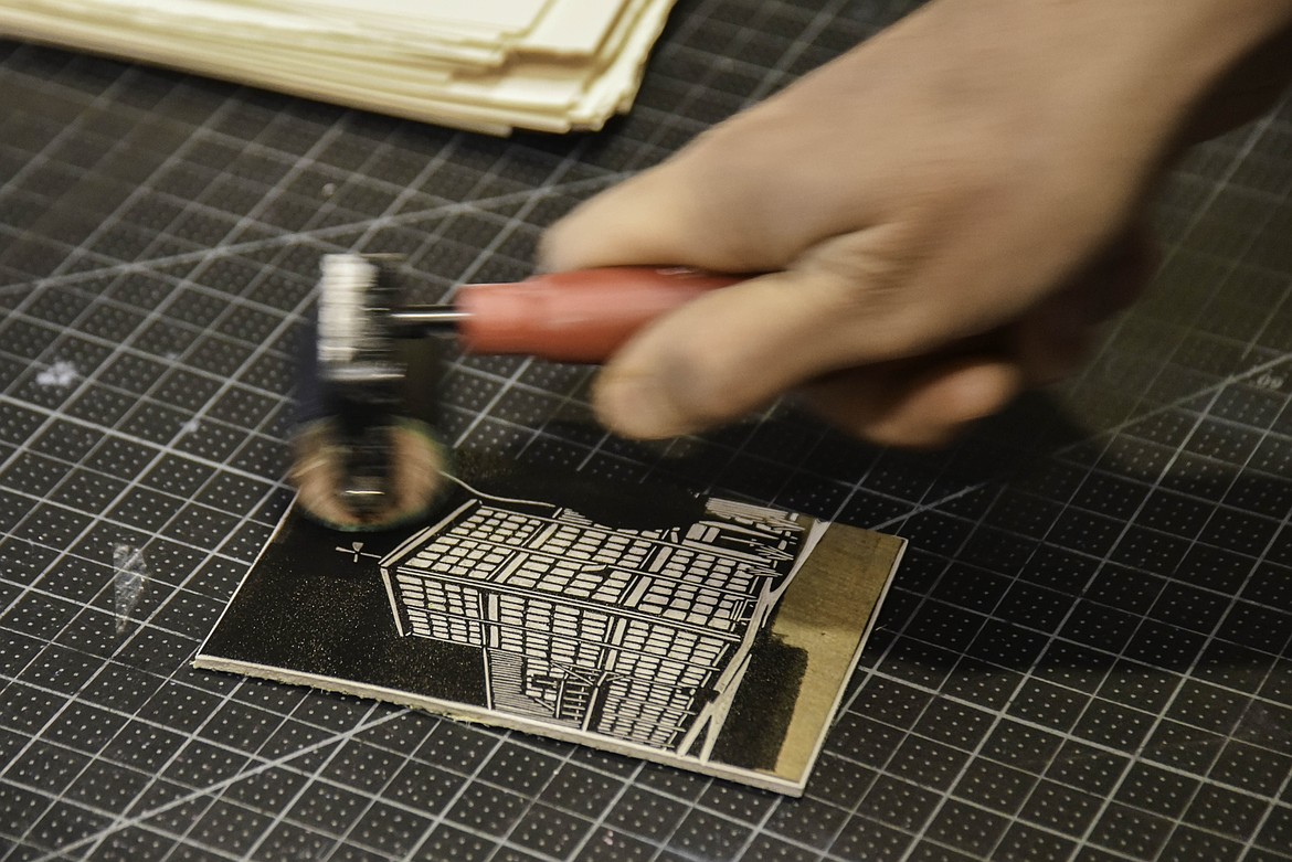 Tarek Penser puts oil based ink on his handcrafted linoleum stamp to make a print. (Kate Heston/Daily Inter Lake)