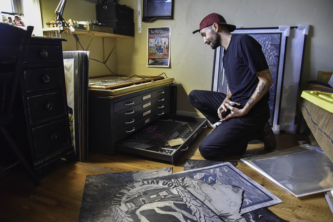 Tarek Penser looks through his studio for previously handcrafted linoleum stamps. (Kate Heston/Daily Inter Lake)