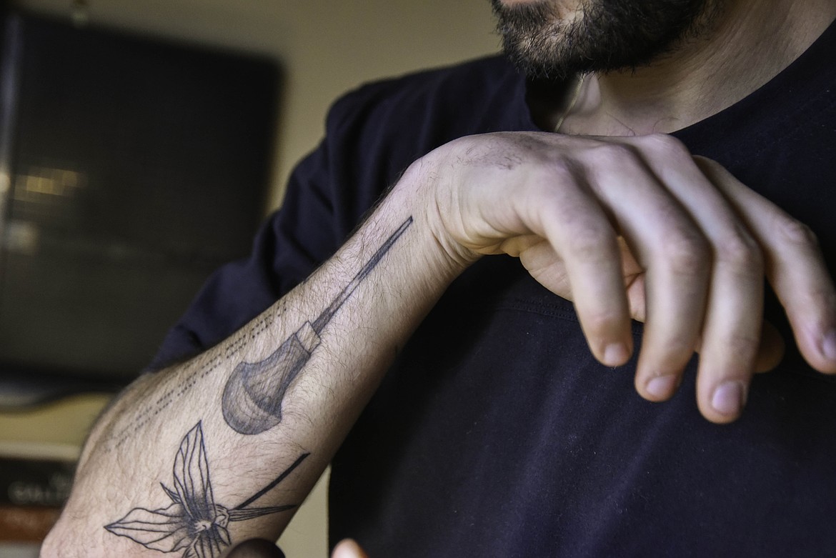 Tarek Penser has a tattoo of a gauge, the tool he uses to carve into the lineolum while making prints. (Kate Heston/Daily Inter Lake)