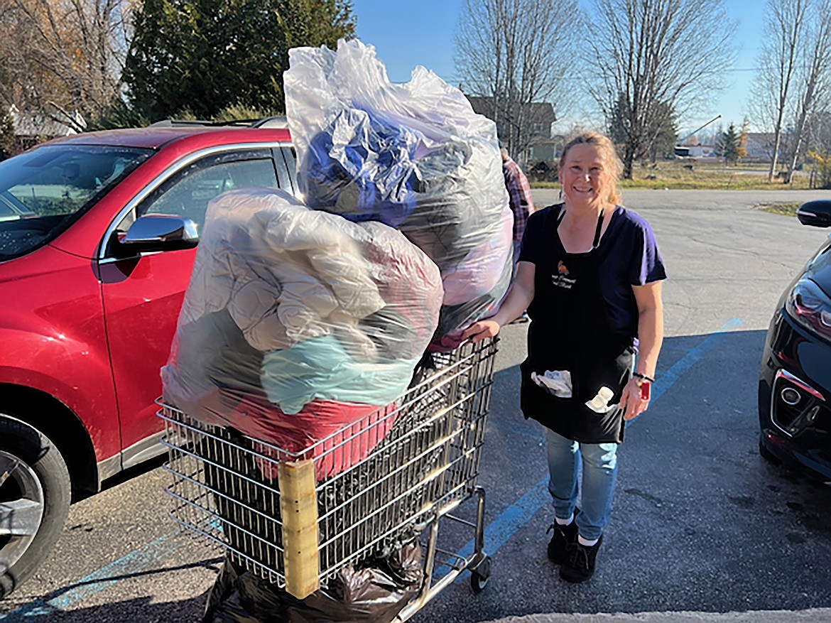 A volunteer brings a shopping cart loaded high with coats to distribute to local youth as part of the annual Coats 4 Kids drive.