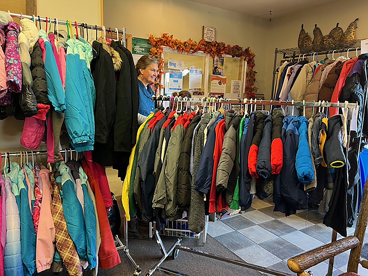 A volunteer is mostly hidden behind racks of coats available as part of the annual Coats 4 Kids drive. Coats can be found at the Sandpoint and Priest River locations of the Bonner Community Food Bank.