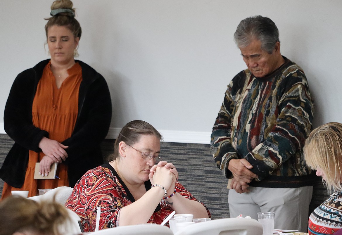 People bow their heads in prayer before a Thanksgiving meal at The Altar Church.