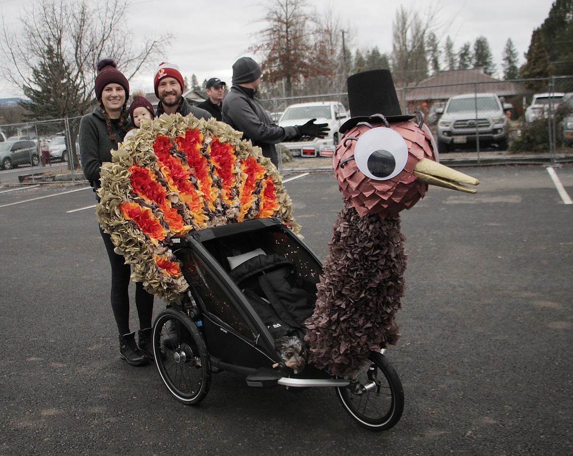 Jake, Payton and Freyja Smith pose for a photo by their stroller-based float before the start of Thursday's Turkey Trot benefit run.