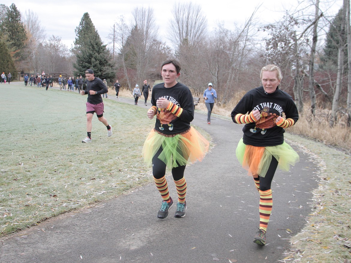 Harlie Mays and Kelli Sorrell run through Travers Park as they take part in Sandpoint's annua Turkey Trot benefit run.