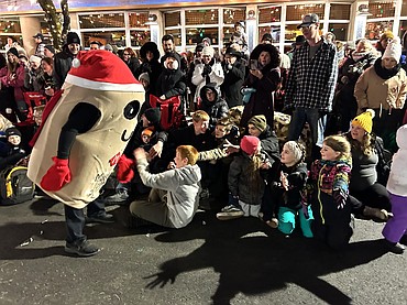 Masher the Potato runs along and high fives the crowd in the Coeur d’Alene Downtown Association's Lighting Ceremony Parade on Friday.