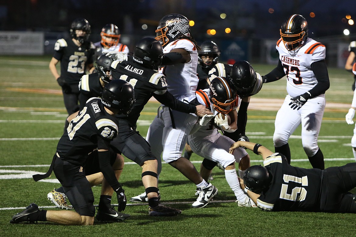 A group of Royal defenders combine for a tackle during the first half of Saturday’s state semifinal game against Cashmere. The Knights held the Bulldogs to just seven points in the win.