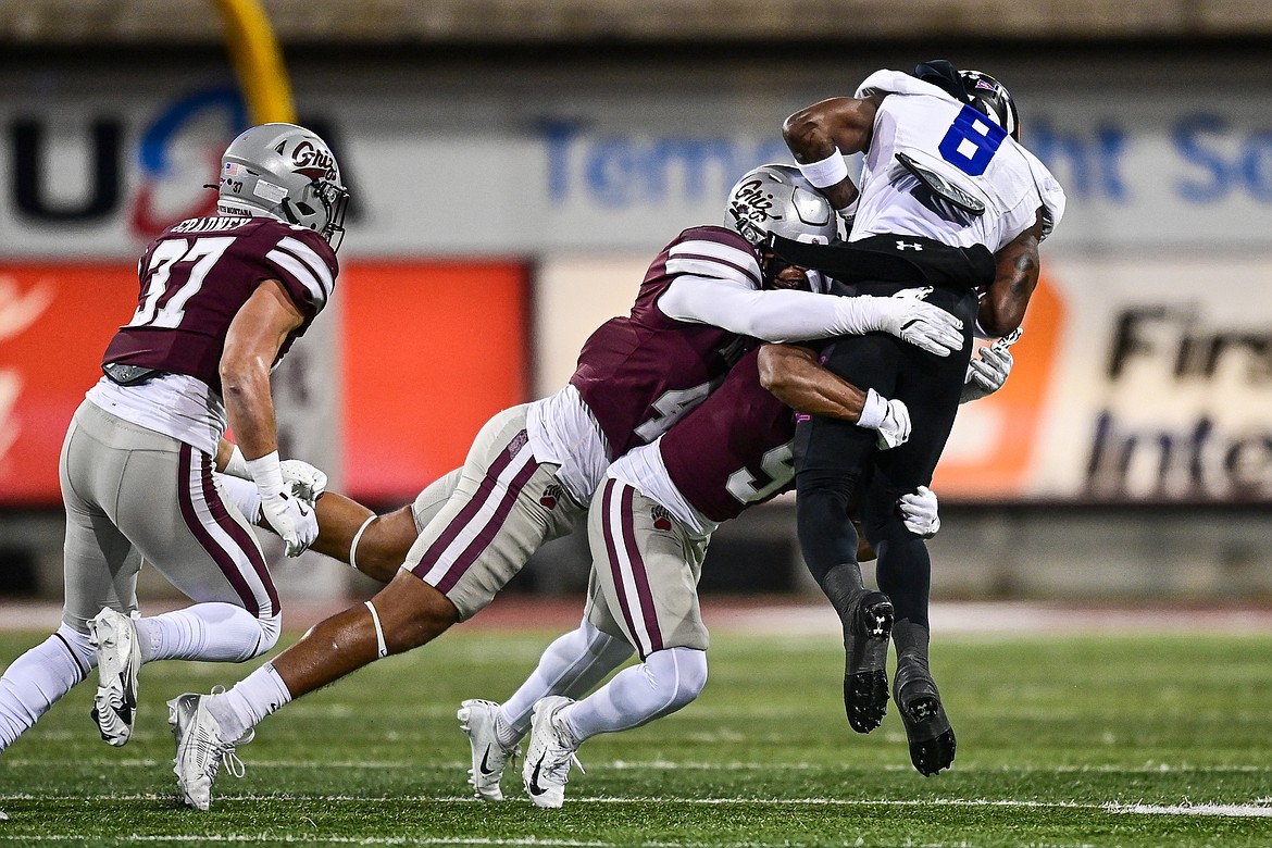 Grizzlies defenders Hayden Harris (48) and Crishawn Gordon (9) wrap up Tennessee State wide receiver Jalal Dean (8) in the first quarter at Washington-Grizzly Stadium on Saturday, Nov. 30. (Casey Kreider/Daily Inter Lake)