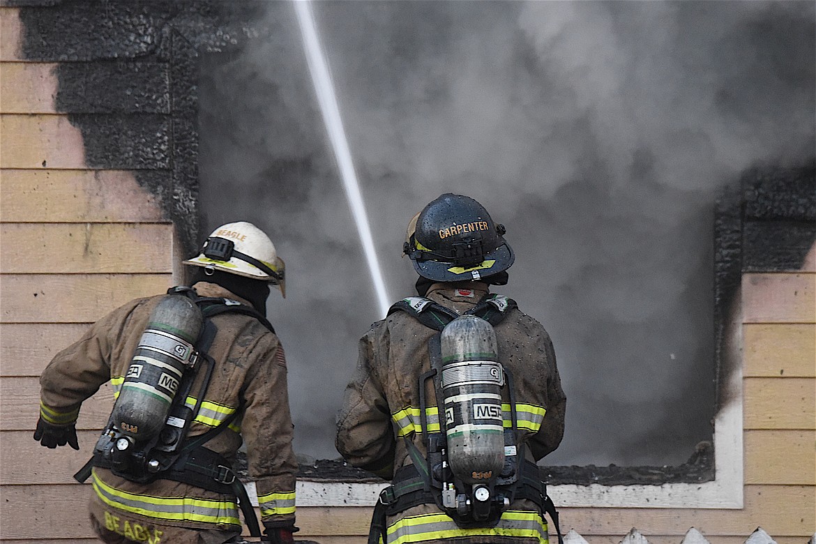 Libby Volunteer Fire Department's Ryan Carpenter sprays water on a house fire at the corner of California Avenue and West Spruce Street in Libby Sunday, Dec. 1, 2024. (Scott Shindledecker/The Western News)