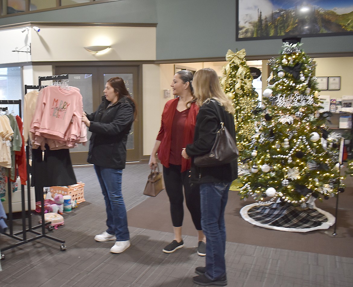 From left: Melanie Pruneda, Heather Ramirez and Marianne Reynolds look over the racks outside Little Peanut Swap in the Smith-Martin Building in Moses Lake. The three were actually out shopping for a wedding dress for Ramirez, they said, but got distracted looking at clothes for grandchildren in the process.