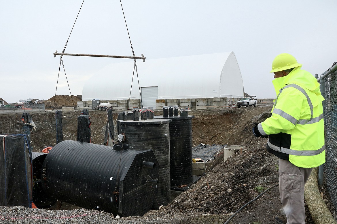 Ken Windram of the Hayden Area Regional Sewer Board watches as crews install a storage tank.