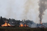 Slash pile burning visible from I-90 in Post Falls