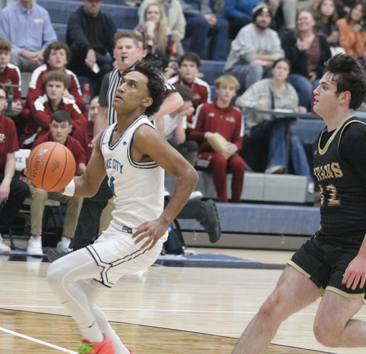 JASON ELLIOTT/Press
Lake City senior guard Cason Miller drives to the basket as University's Quinn Lipke defends during the first quarter of Tuesday's game at Lake City High.