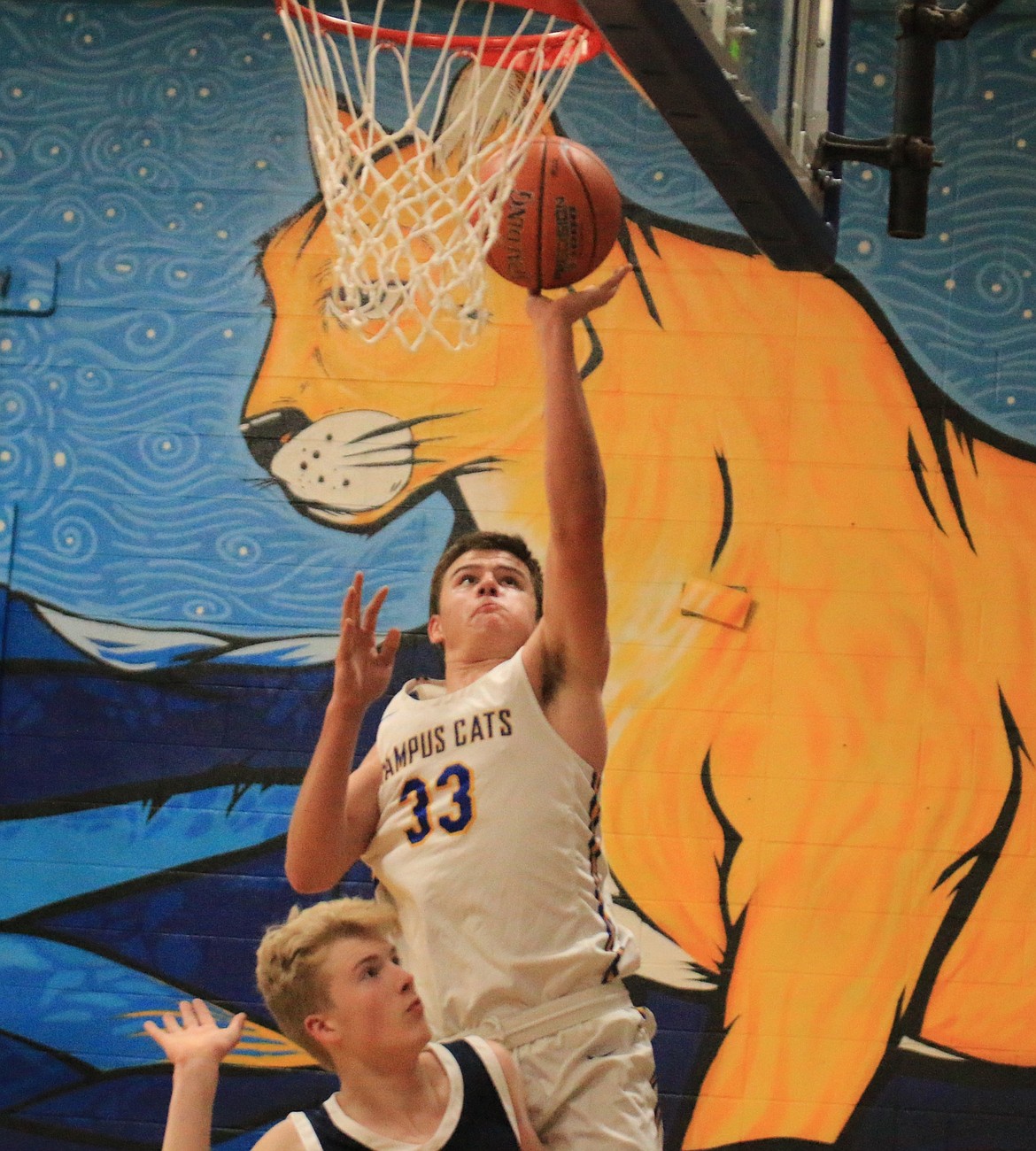 Clark Fork High junior Owen Howard finishes a layup in transition while guarded by Coeur du Christ High junior Aedan O'Neill during Tuesday's season opener.