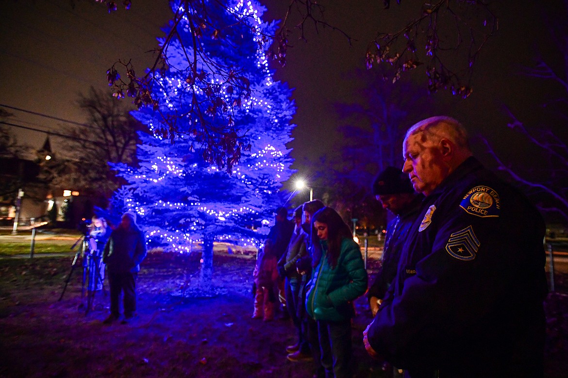 Attendees bow their heads for a moment of prayer at the Blue Light Christmas Tree Lighting ceremony outside the Flathead County Justice Center in Kalispell on Tuesday, Dec. 3. The event is held in support of the families of fallen officers and to honor the officers, firefighters, first responders and all those who serve and protect. (Casey Kreider/Daily Inter Lake)