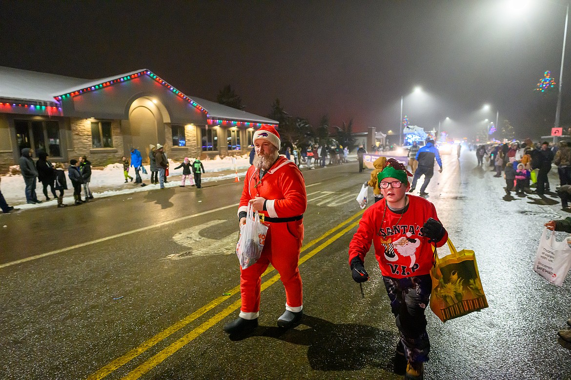 Santa and a helper hand out candy.