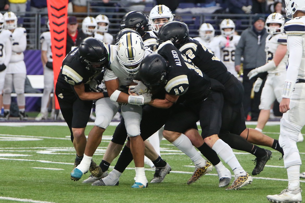 Royal defenders group up for a tackle in the first half against Seton Catholic. The Knights turned the Cougars over four times in the second half – two fourth-down stops and three interceptions.