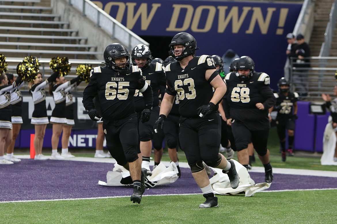 Royal seniors Eliezer Vivar (65) and Asher Garnick (63) lead the Knights out of the tunnel ahead of Friday’s state championship game against Seton Catholic.