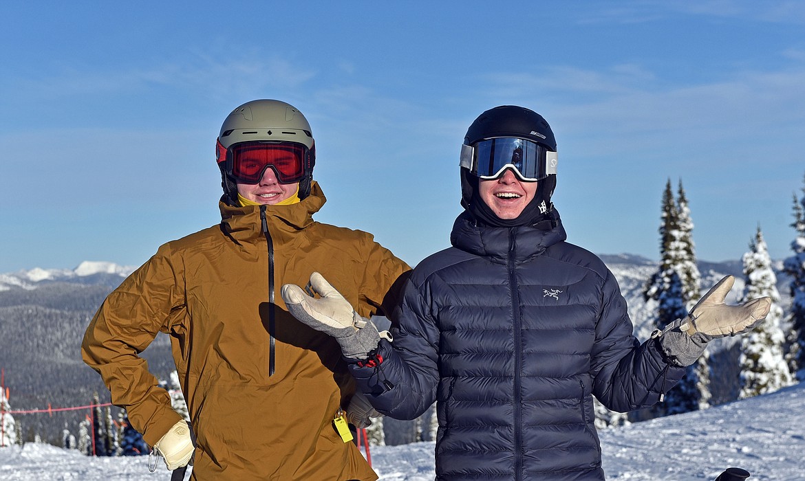 Otto Klein and Colby Minton enjoy the sunshine at the summit before heading down the backside on opening day last Thursday. (Julie Engler/Whitefish Pilot)