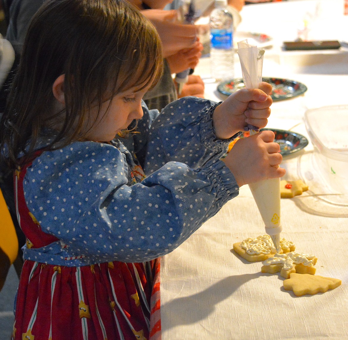 Some children went all out with mountains of frosting, others like Tessa, worked slowly and diligently to make their snowflakes beautiful.  (Amy Quinlivan)