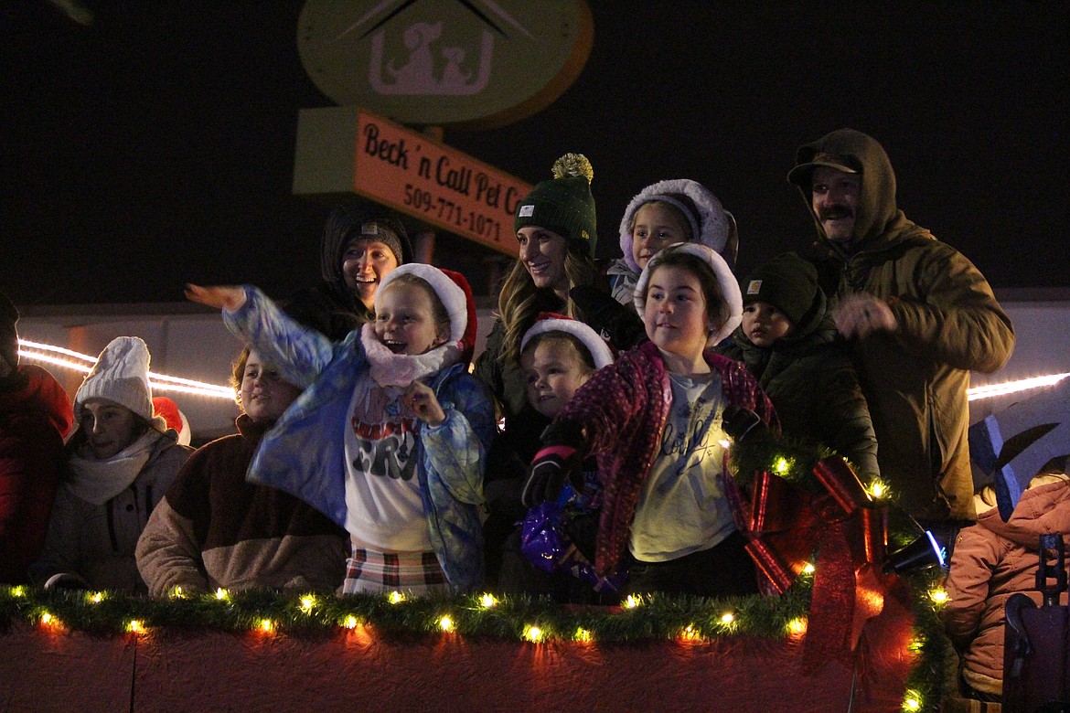 Children throw out candy and wave to their friends from a float in the Ag Parade Dec. 6.