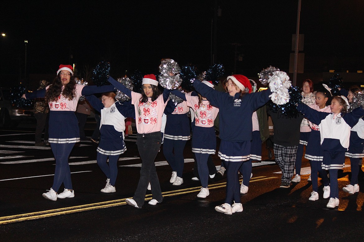 Cheerleaders lead a chant as they march down Third Street.