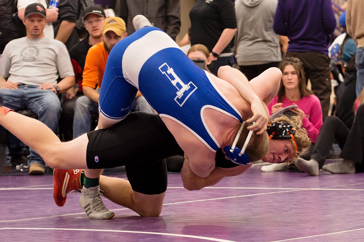 Plains 190-pounder David Chapman (black) rolls T Falls Gabe Hutton (blue) into position for a potential fall during the Owen Invitational wrestling meet this past weekend in Polson.  (Photo by Teresa Waterbury)