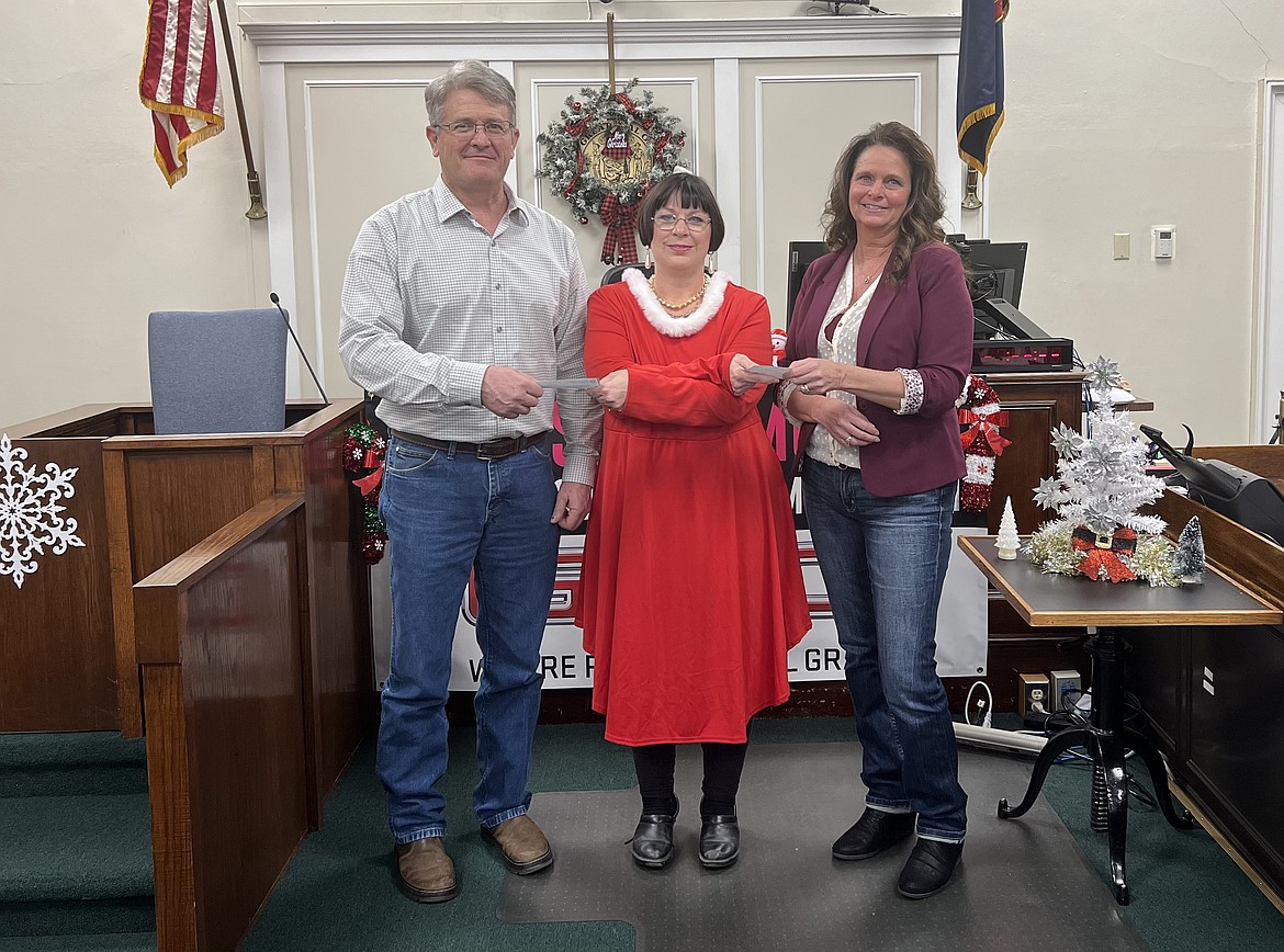 Shoshone County Clerk-elect Lori Osterberg accepts checks from commissioner Jeff Zimmerman and Tracy Casady during the annual Silver Valley Community Christmas Fund telethon at the Shoshone County Courthouse last week.