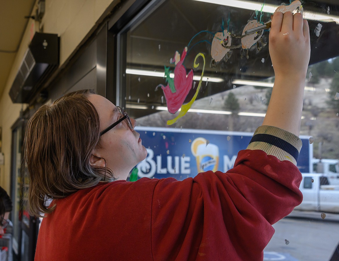 Senior Ava Warta paints a Santa and sleigh at McGowan Grocery. (Tracy Scott/Valley Press)