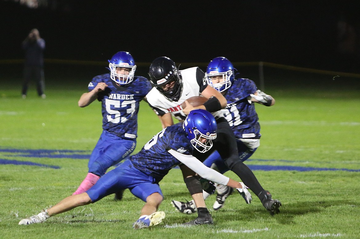 A trio of Warden defenders swarm to tackle a River View receiver. The Cougars ended the fall with a 5-5 record.