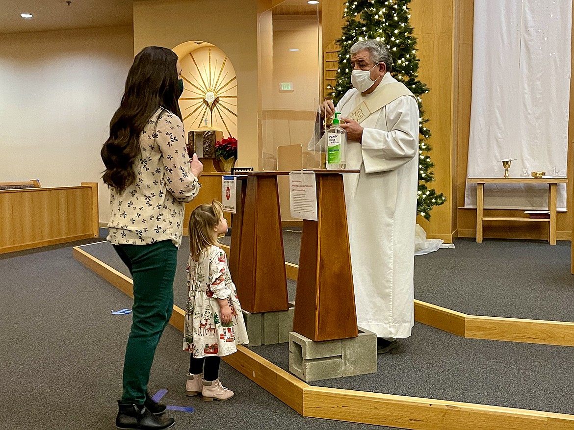 Deacon Frank Martinez, right, prepares to give communion to a worshiper during a Christmas Eve mass at Our Lady of Fatima Catholic Parish in Moses Lake in 2020.