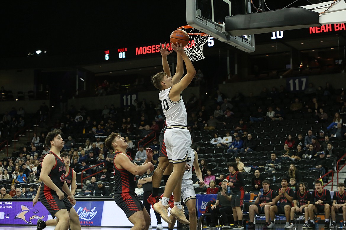 MLCA/CCS sophomore Max Gulenko, in white, lays the ball in for a basket during a game against Neah Bay at last season’s state tournament. Lions Head Coach Emerson Ferguson said Gulenko has made a significant leap in on-court production this season.