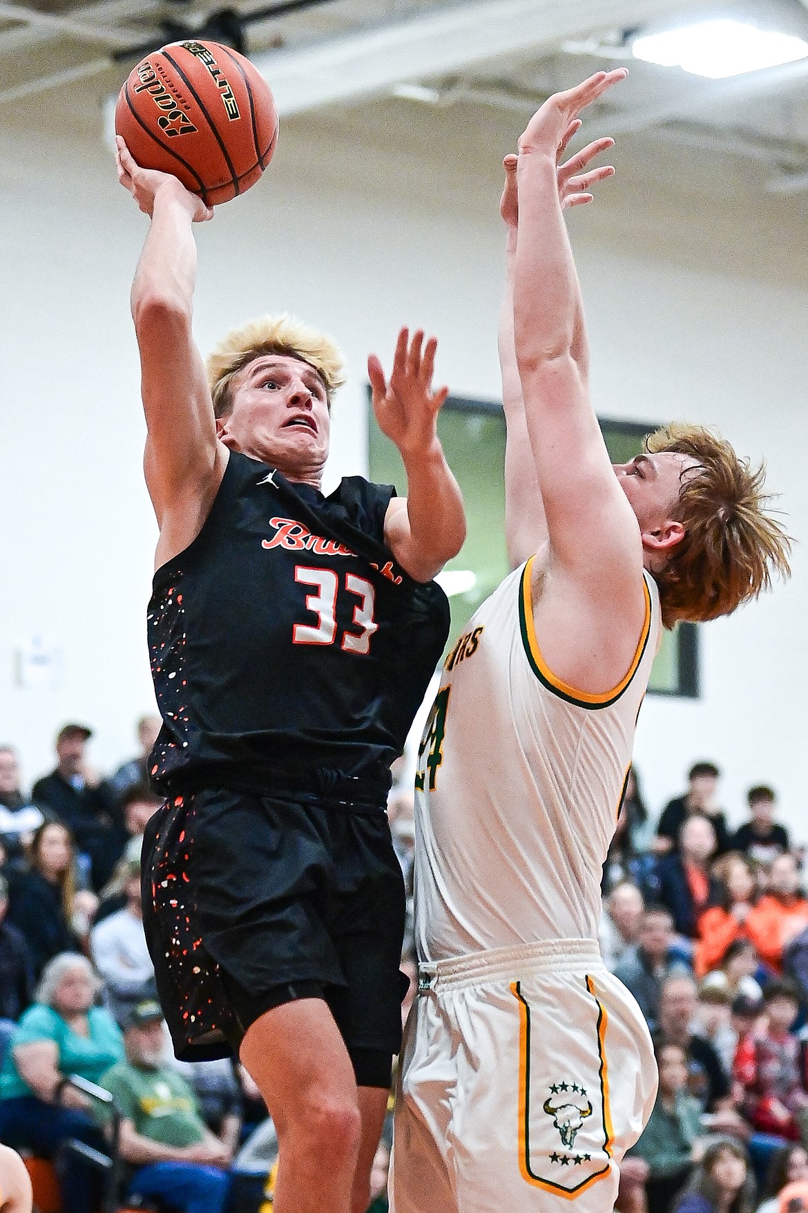 Flathead's Korbin Eaton (33) drives to the basket guarded by Great Falls CMR's Dean Blair (24) in the first quarter inside Gene Boyle Gymnasium at Flathead High School on Saturday, Dec. 14. (Casey Kreider/Daily Inter Lake)