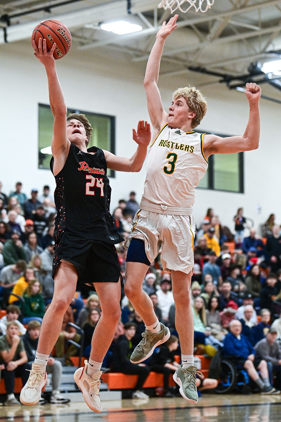 Flathead's Brodee Zahn (24) drives to the basket guarded by Great Falls CMR's Nate Reeves (3) in the first quarter inside Gene Boyle Gymnasium at Flathead High School on Saturday, Dec. 14. (Casey Kreider/Daily Inter Lake)