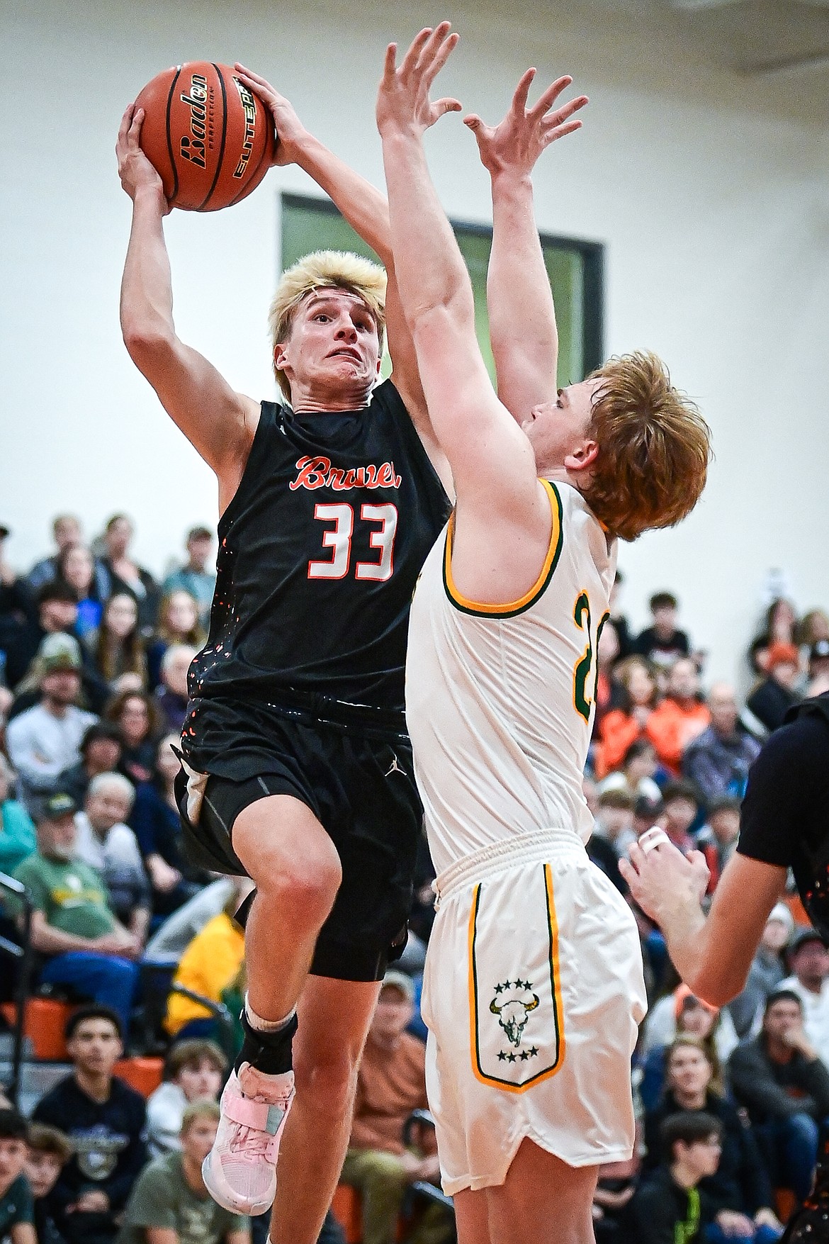 Flathead's Korbin Eaton (33) drives to the basket guarded by Great Falls CMR's Dean Blair (24) in the first quarter inside Gene Boyle Gymnasium at Flathead High School on Saturday, Dec. 14. (Casey Kreider/Daily Inter Lake)