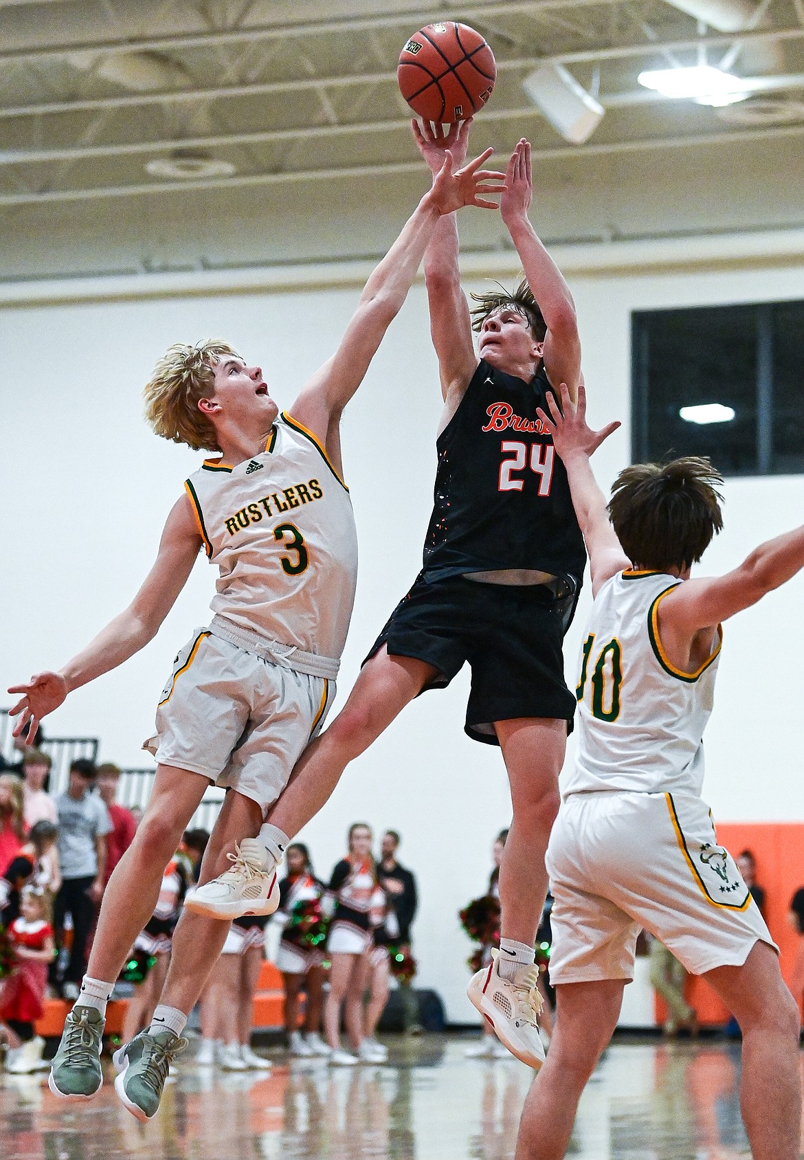 Flathead's Brodee Zahn (24) shoots a jumper guarded by Great Falls CMR's Nate Reeves (3) and Brady Henzel (10) in the second quarter inside Gene Boyle Gymnasium at Flathead High School on Saturday, Dec. 14. (Casey Kreider/Daily Inter Lake)