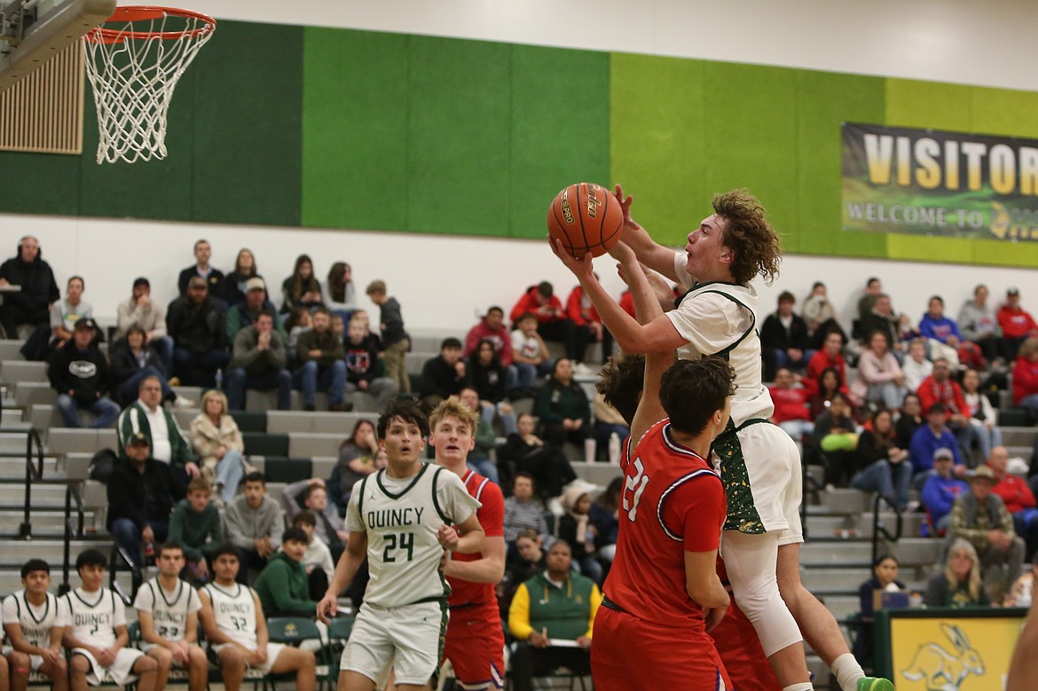 Quincy sophomore Dwane Lind, in white, drives toward the basket during the second half against Prosser on Friday. Lind finished the game with 11 points.