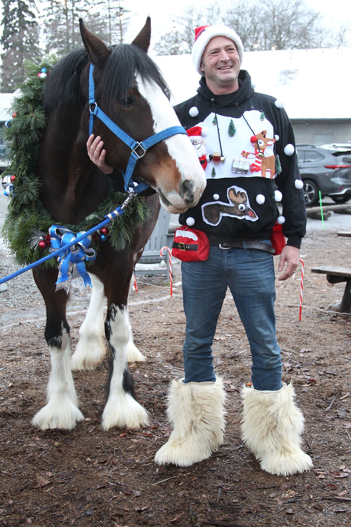 Kevin Wetzel gets his picture taken with Missy, a Parnell Ranch Clydesdale, at Saturday's SantaCon event.