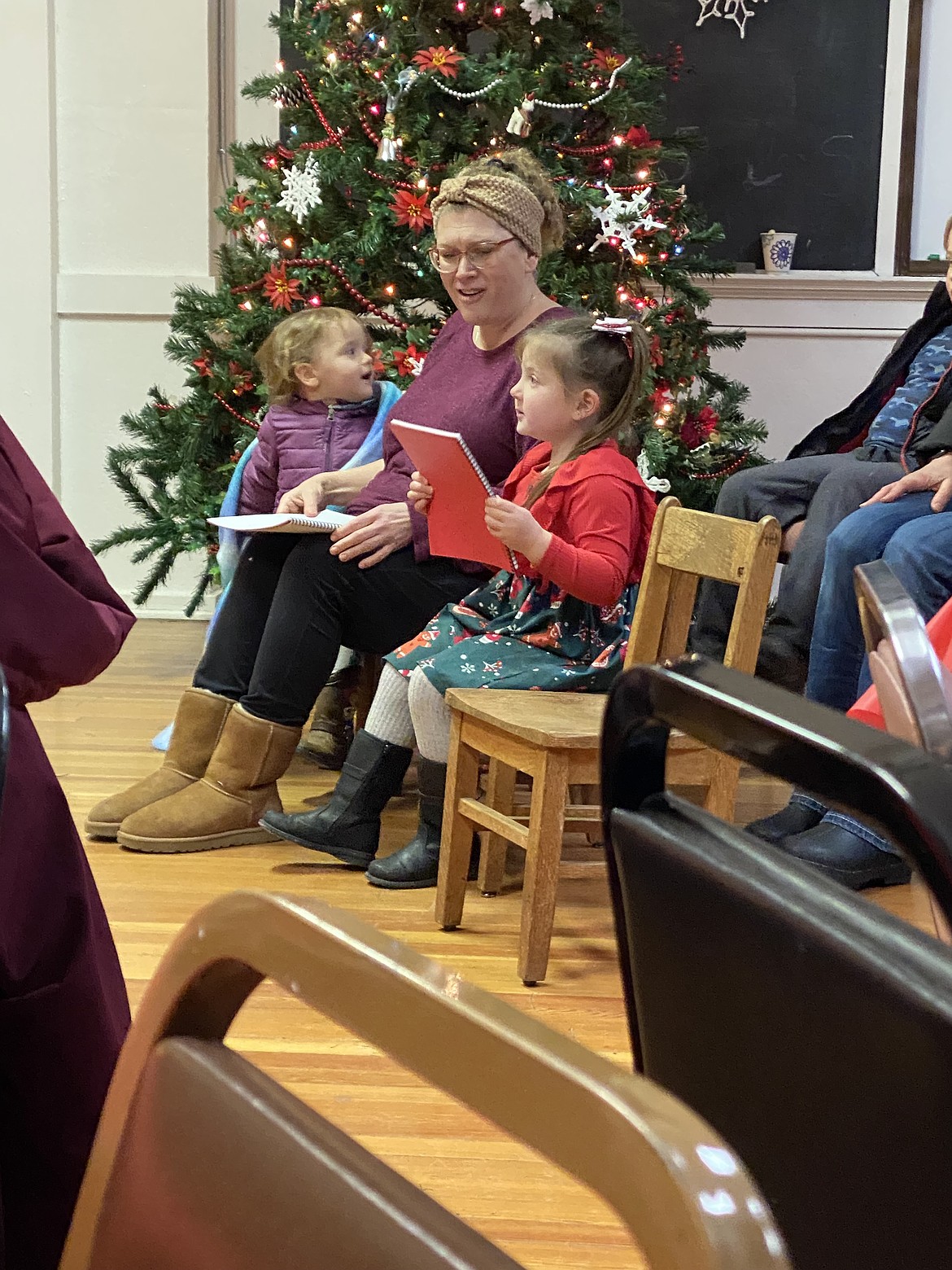 Children sing Christmas carols while waiting for Santa to arrive.