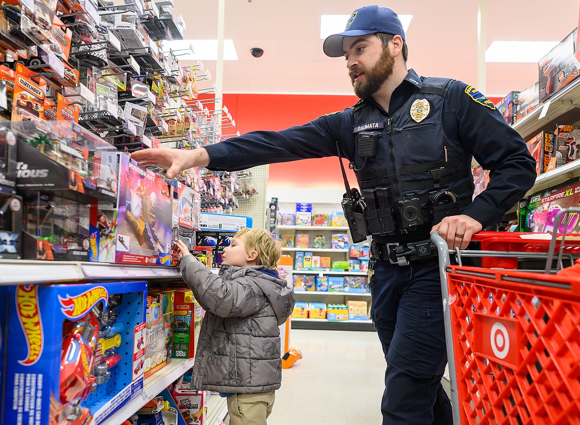 Columbia Falls police officer Jake Dalimata helps a youngster shop for toys at Target during the annual Shop with a Cop program that helps less fortunate kids have a good Christmas.