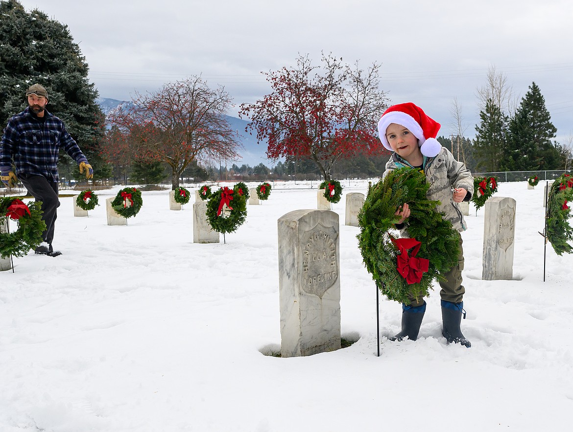 Youngster Luke Rolfing adjusts a wreath during the Wreaths Across America ceremony at the Montana Veterans Home Cemetery Saturday.