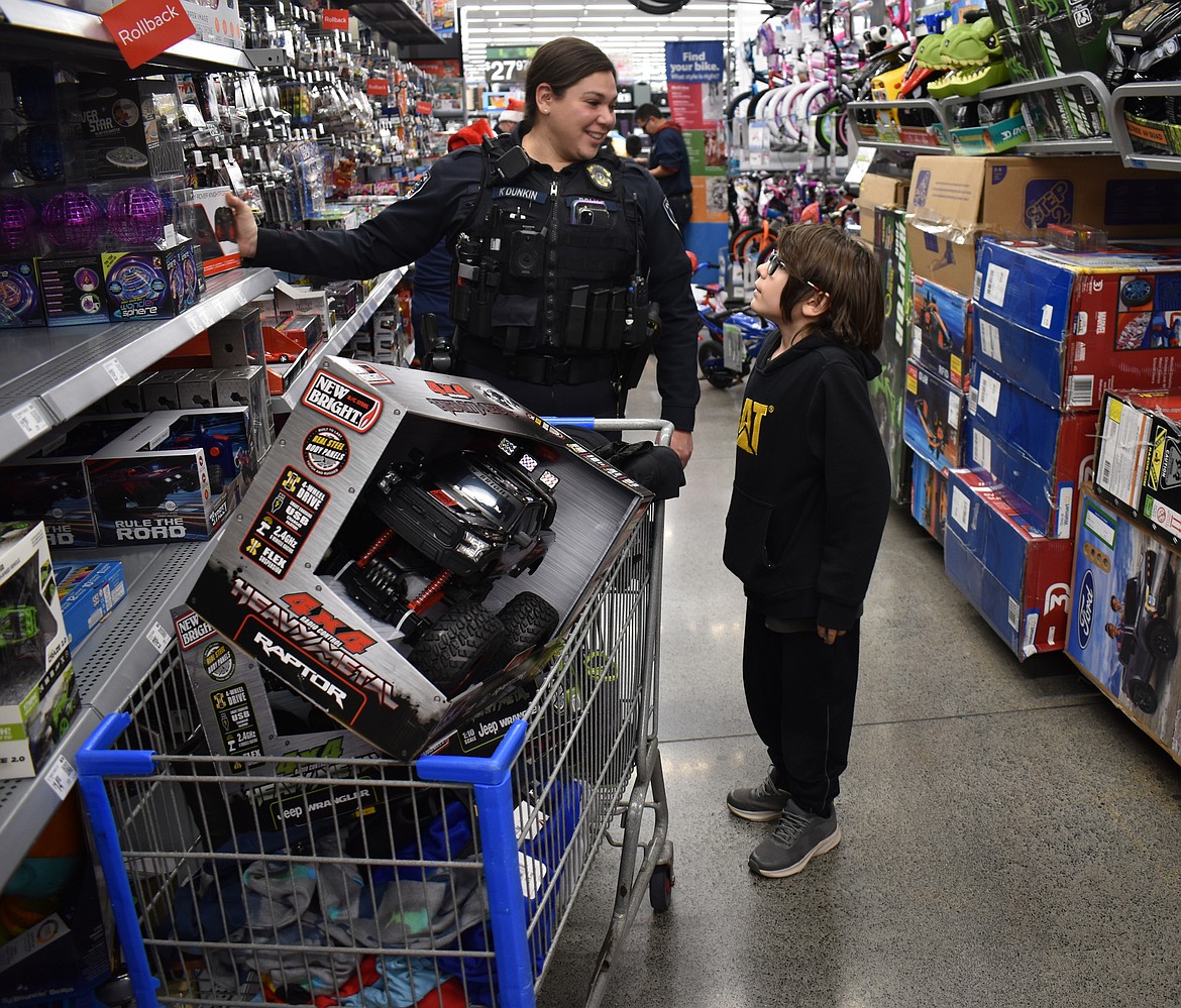 Parker Van Blaricom, 9, discusses toy options with Moses Lake Police Officer Kaydren Dunkin at Shop with a Cop Tuesday.