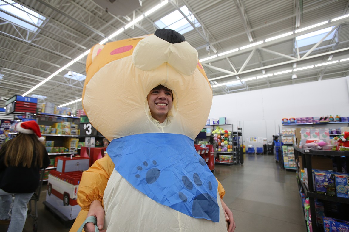 Lake City High School senior Landon Burt scurries through the Hayden Walmart during a holiday shopping trip Wednesday morning as part of the annual Give Back Project.