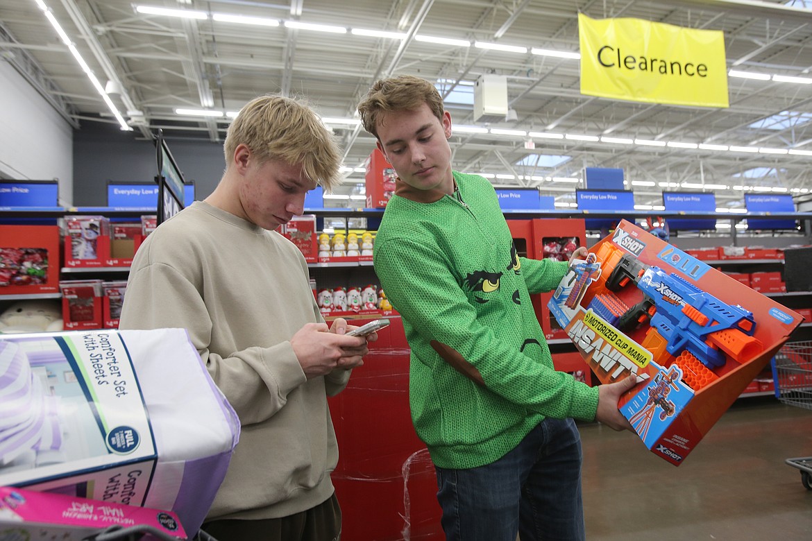 Lake City High seniors Brycen Duboise, left, and Harman Gaby double-check their holiday shopping list Wednesday morning.