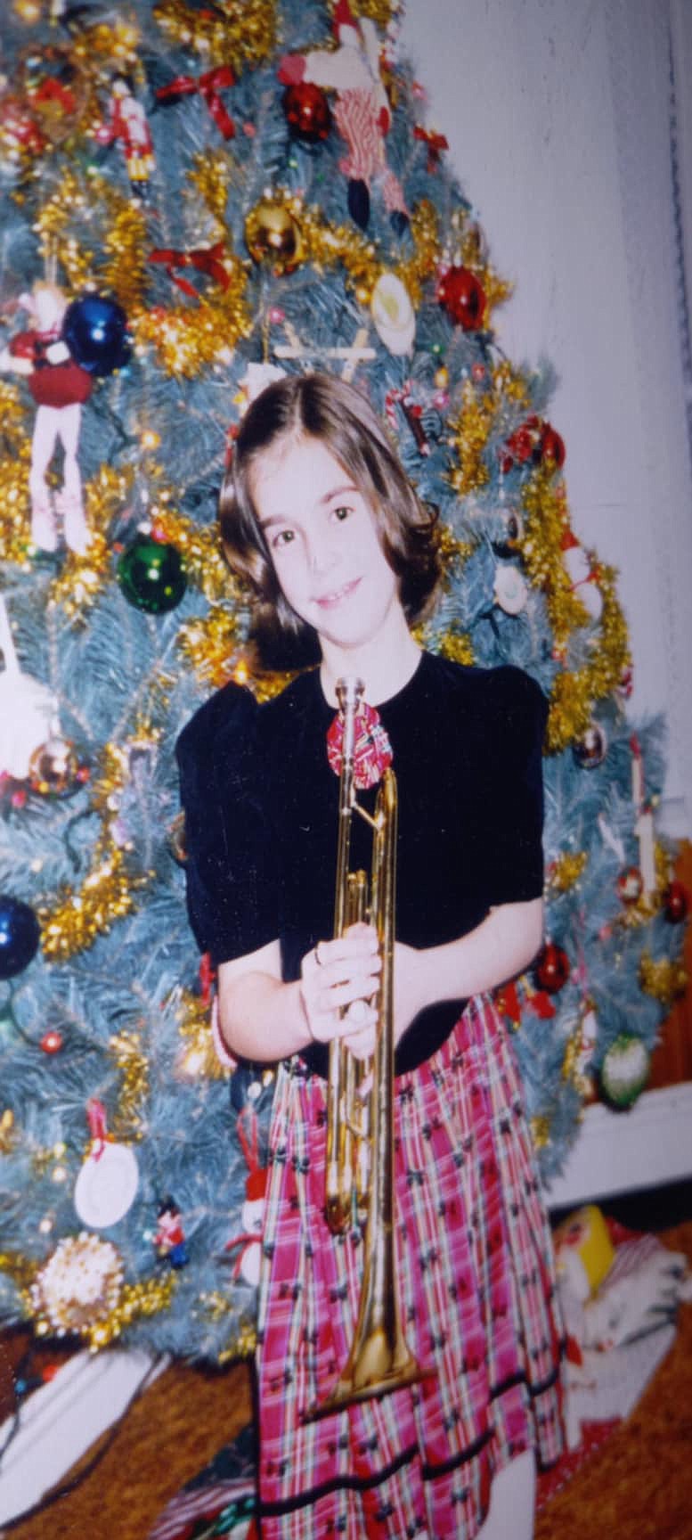 Carolyn Bostick preparing to celebrate Christmas by singing and playing trumpet in a school concert in 1998 in Central New York.