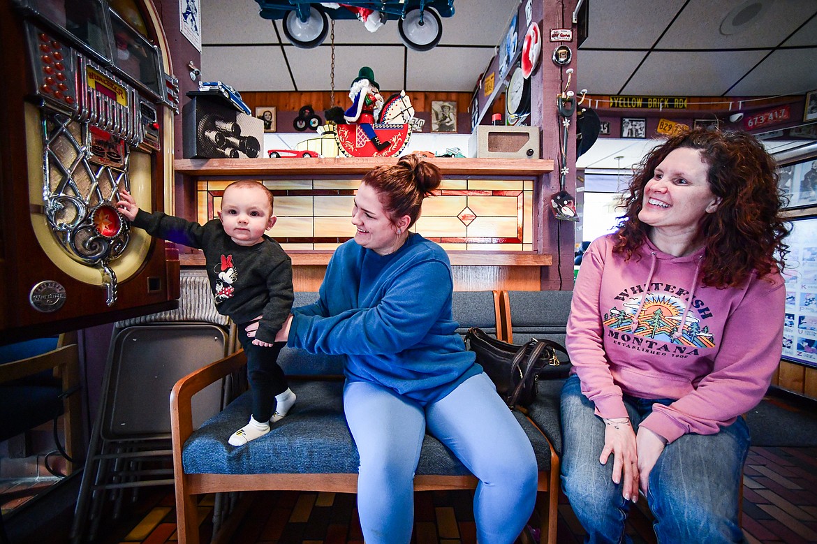 Brielle Hammer's 1-year-old daughter Oakli plays with the jukebox as they wait for a table with Hammer's mother Alex Engler at Bojangles Diner in Kalispell on Thursday, Dec. 19. (Casey Kreider/Daily Inter Lake)